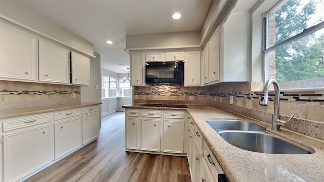 kitchen featuring sink, black appliances, white cabinetry, and light hardwood / wood-style floors