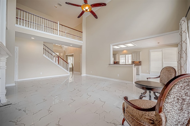 interior space featuring ceiling fan and a high ceiling