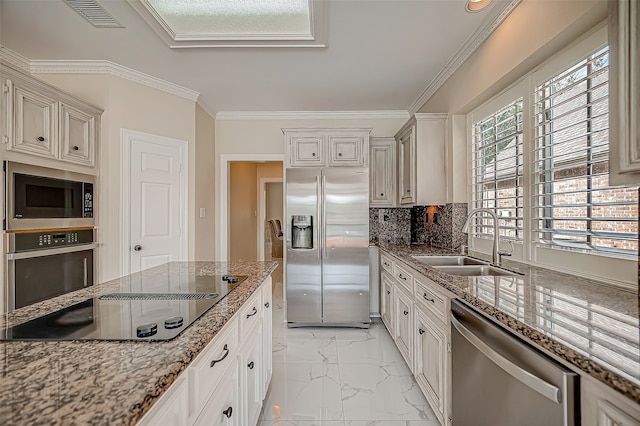 kitchen with backsplash, light stone counters, stainless steel appliances, crown molding, and sink