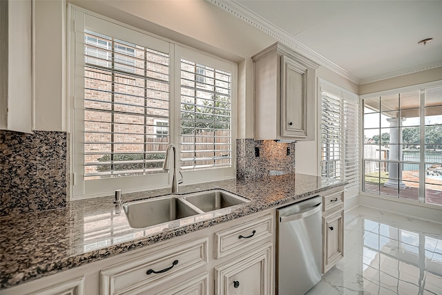 kitchen with stainless steel dishwasher, sink, backsplash, and dark stone counters