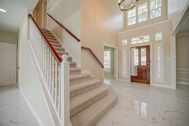 foyer featuring a towering ceiling and an inviting chandelier