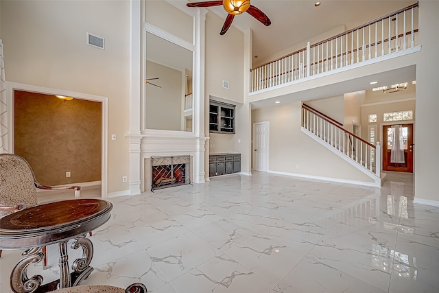 living room featuring ceiling fan and a high ceiling