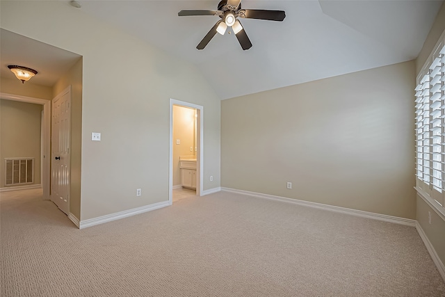 unfurnished bedroom with ceiling fan, ensuite bathroom, lofted ceiling, and light carpet