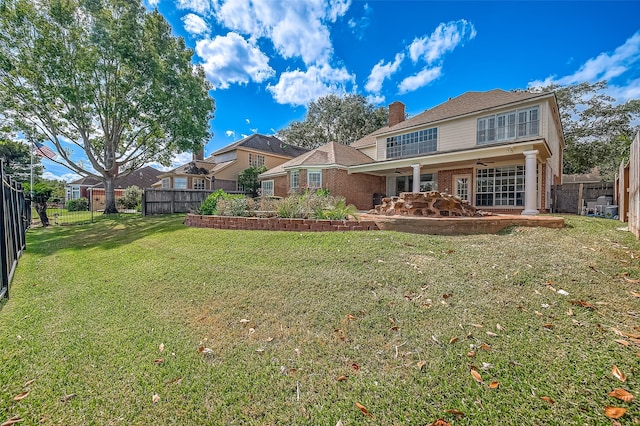 back of house featuring ceiling fan and a yard