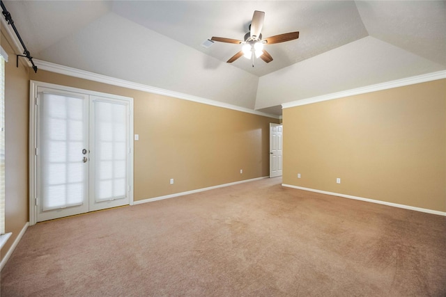 carpeted spare room featuring a raised ceiling, crown molding, ceiling fan, french doors, and lofted ceiling