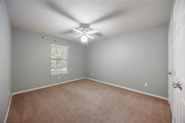 carpeted empty room with a textured ceiling and ceiling fan