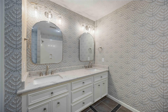 bathroom featuring a textured ceiling, tile patterned floors, and vanity