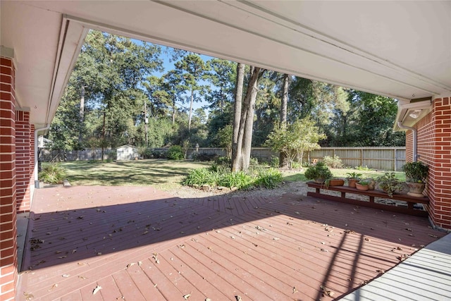 wooden terrace featuring a yard and a shed