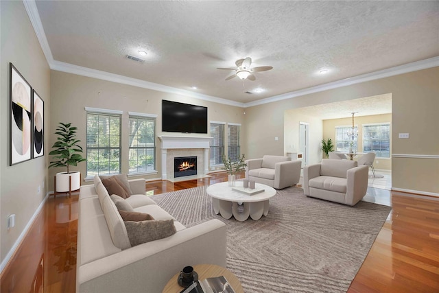 living room with a textured ceiling, ornamental molding, ceiling fan with notable chandelier, and wood-type flooring