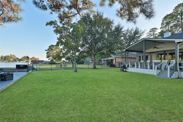 view of yard featuring a water view and ceiling fan