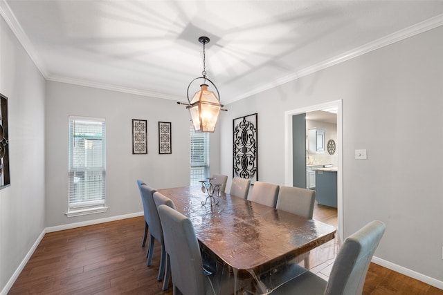 dining space with dark wood-type flooring and crown molding