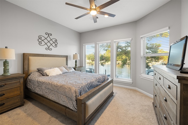 bedroom with ceiling fan, multiple windows, and light colored carpet