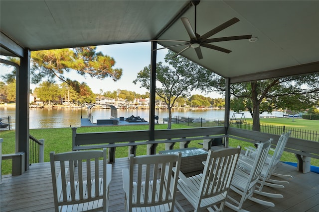 wooden terrace featuring a water view, ceiling fan, and a yard