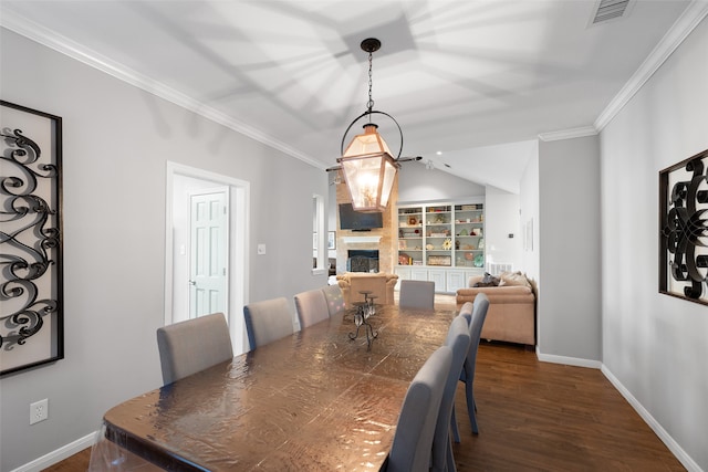 dining area featuring ornamental molding, a fireplace, and dark hardwood / wood-style flooring