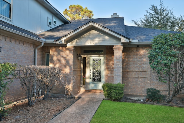 property entrance with a lawn