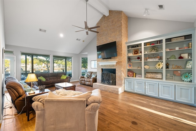 living room with beam ceiling, a brick fireplace, light wood-type flooring, high vaulted ceiling, and ceiling fan