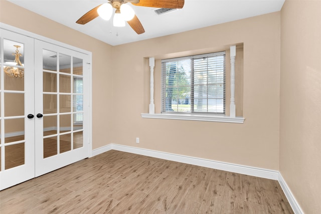 empty room with french doors, light hardwood / wood-style floors, and ceiling fan