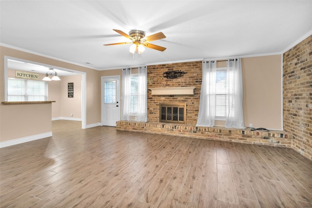 unfurnished living room featuring a healthy amount of sunlight, wood-type flooring, and ornamental molding