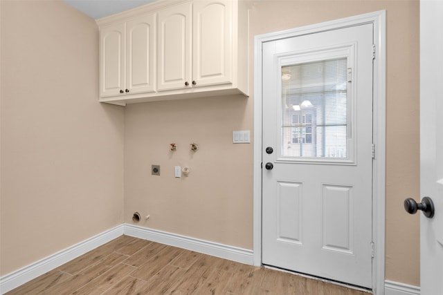 laundry room featuring cabinets, hookup for a washing machine, electric dryer hookup, light hardwood / wood-style floors, and hookup for a gas dryer