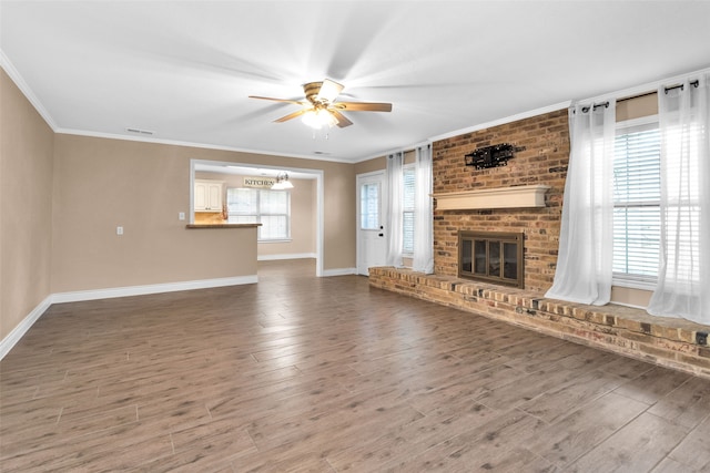 unfurnished living room with crown molding, a healthy amount of sunlight, and hardwood / wood-style flooring