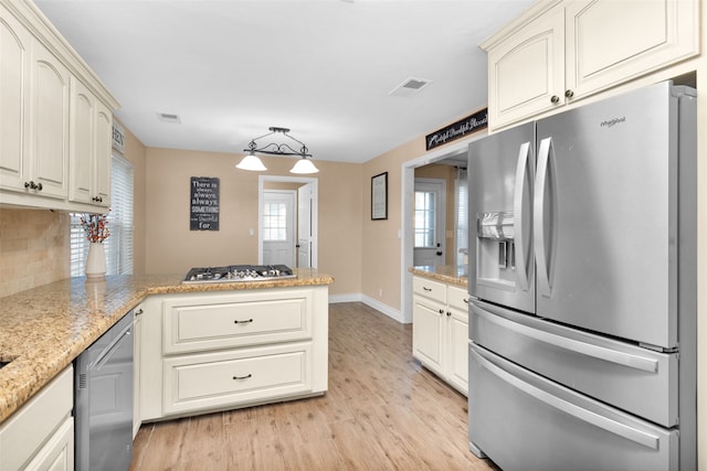 kitchen featuring kitchen peninsula, decorative backsplash, light stone countertops, light hardwood / wood-style floors, and stainless steel appliances