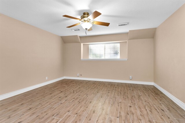 spare room with ceiling fan, lofted ceiling, and light hardwood / wood-style flooring