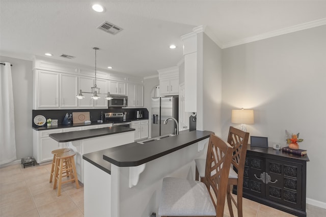 kitchen featuring a breakfast bar area, kitchen peninsula, stainless steel appliances, pendant lighting, and white cabinets