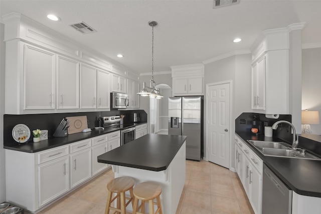 kitchen featuring stainless steel appliances, sink, a kitchen island, and white cabinets