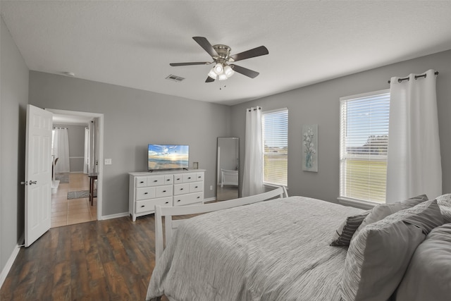 bedroom with dark hardwood / wood-style floors, a textured ceiling, and ceiling fan