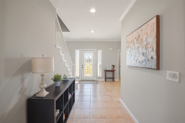 tiled entrance foyer featuring crown molding