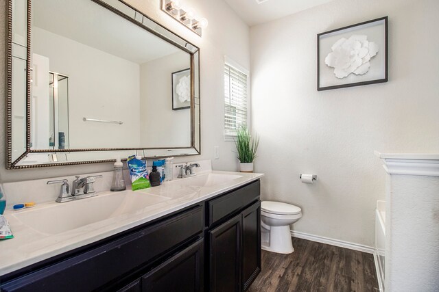 bathroom with vanity, a bathing tub, toilet, and wood-type flooring