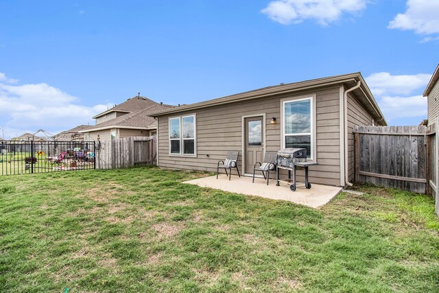 back of house featuring a patio area and a lawn