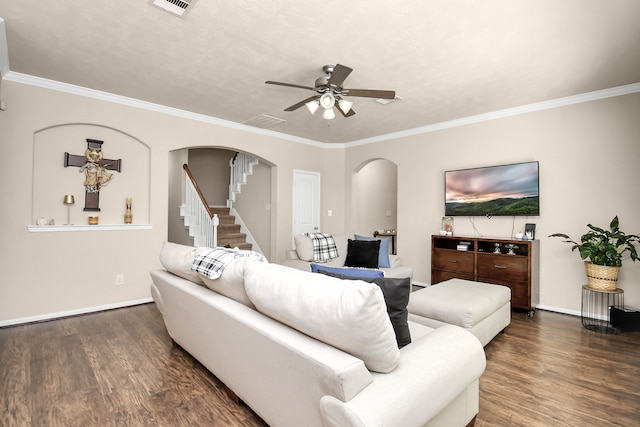 living room with dark wood-type flooring, crown molding, and ceiling fan