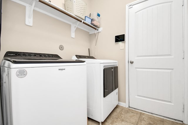 laundry room with washer and dryer and light tile patterned flooring