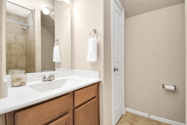 bathroom with vanity and a tile shower