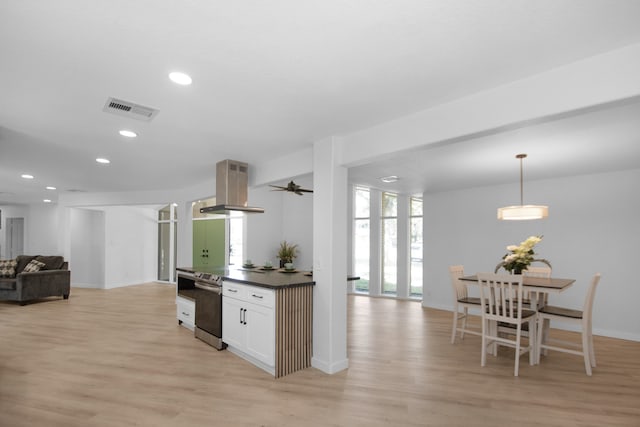 kitchen featuring island exhaust hood, light wood-type flooring, hanging light fixtures, and stainless steel range with electric stovetop