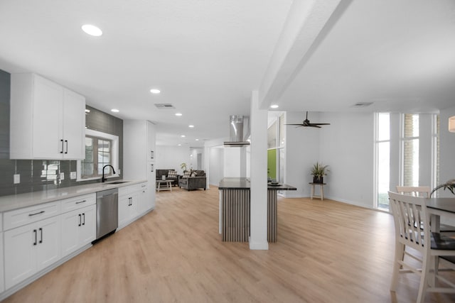 kitchen with sink, white cabinets, stainless steel dishwasher, and light hardwood / wood-style floors