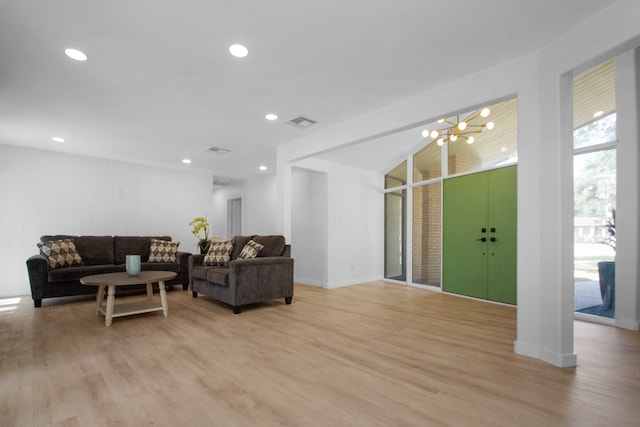 living room with light wood-type flooring and a notable chandelier