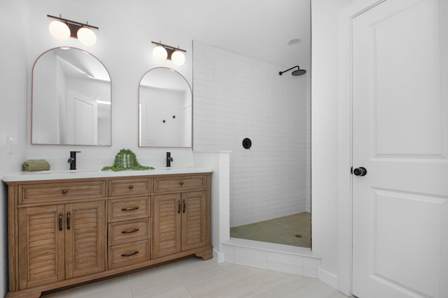 bathroom featuring tile patterned flooring, vanity, and tiled shower