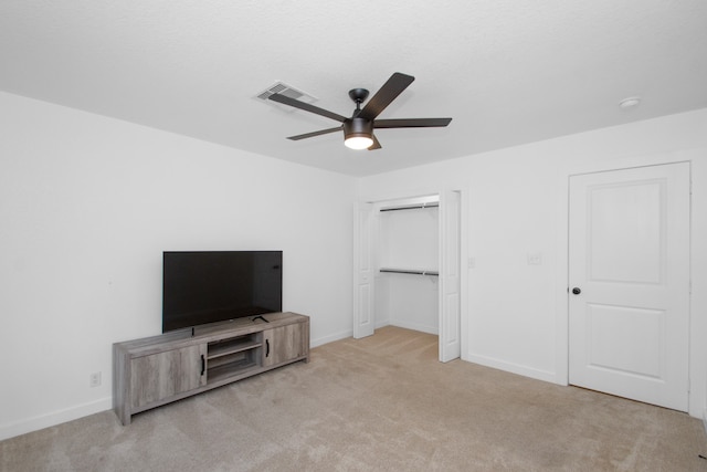 unfurnished bedroom with ceiling fan, light colored carpet, and a closet