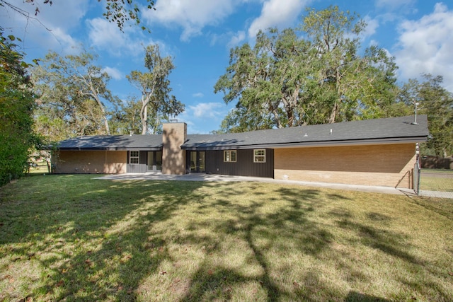 back of property featuring a lawn