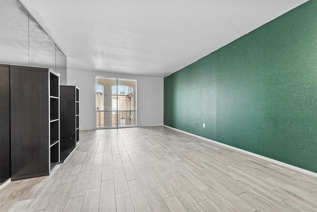 empty room featuring light hardwood / wood-style flooring and a textured ceiling