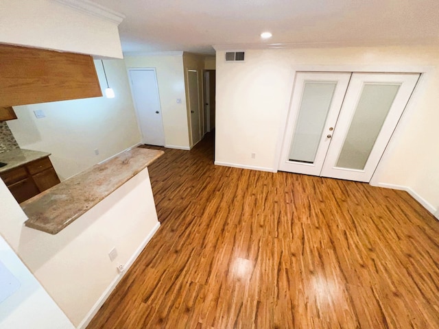 interior space with ornamental molding and hardwood / wood-style floors