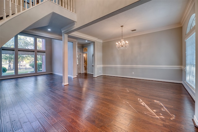 spare room with ornamental molding, a notable chandelier, and dark hardwood / wood-style floors