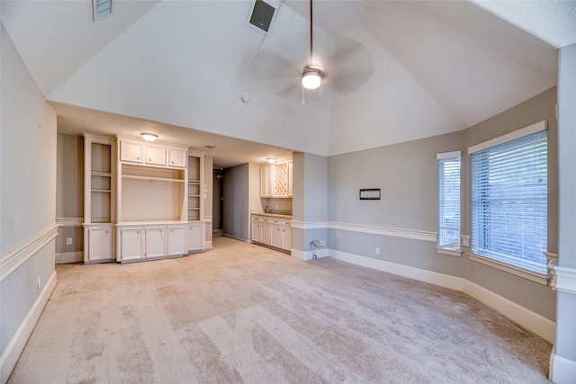 unfurnished living room featuring light carpet, vaulted ceiling, and ceiling fan