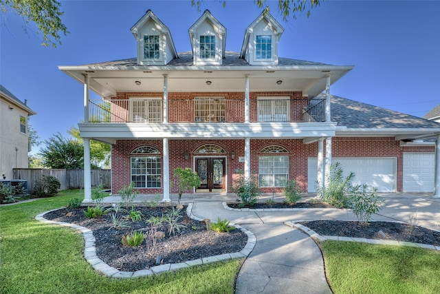 view of front facade with a front yard, cooling unit, a balcony, and a garage