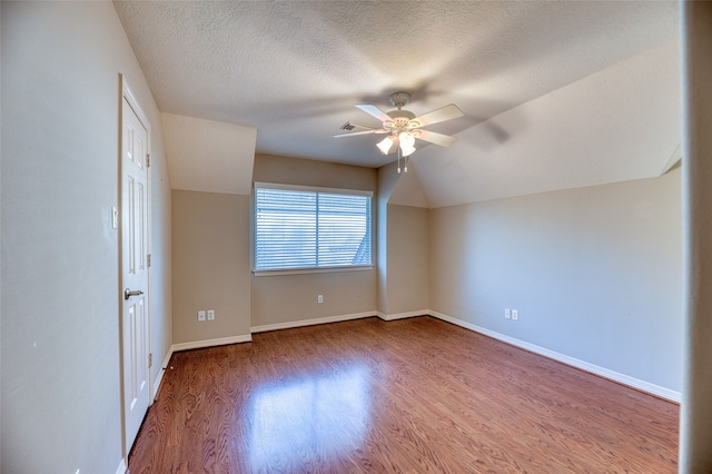 interior space featuring lofted ceiling, hardwood / wood-style floors, a textured ceiling, and ceiling fan