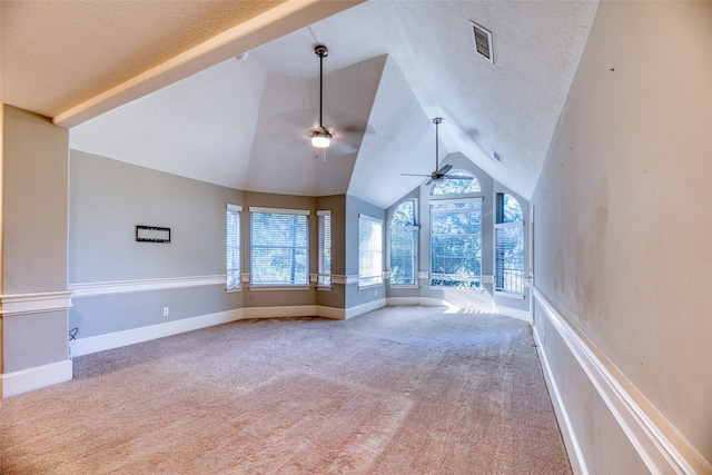 additional living space featuring vaulted ceiling, a textured ceiling, carpet, and ceiling fan