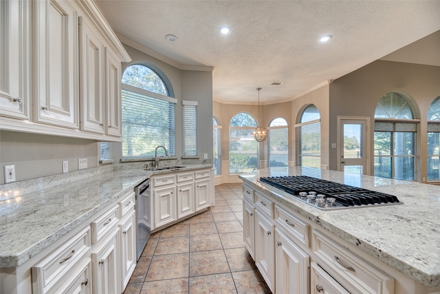 kitchen featuring hanging light fixtures, a textured ceiling, light stone countertops, sink, and stainless steel appliances