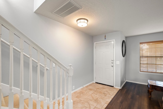 foyer with a textured ceiling and wood-type flooring